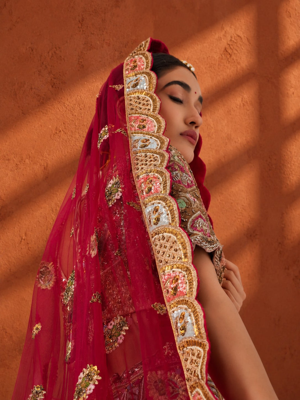 Bride in a red dupatta with an embroidered scalloped border