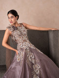 Model in a mauve gown with a sculpted floral shoulder and silver embellishment